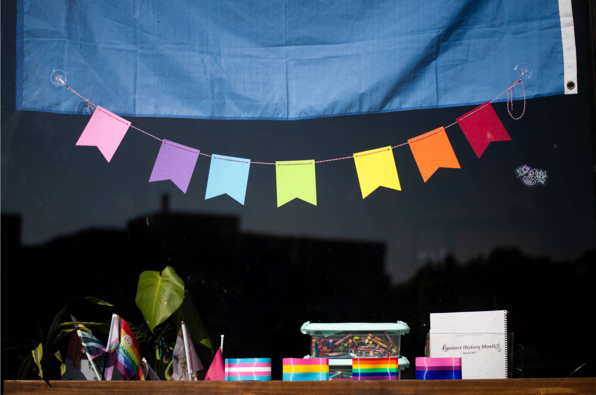 A rainbow banner hangs from the window of the Milton E. Ford LGBT Resource Center